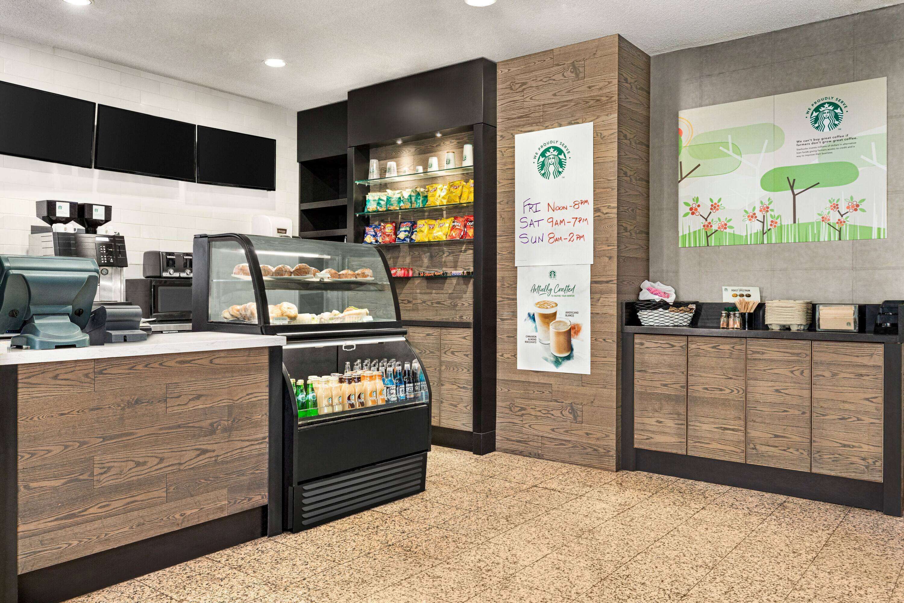 A coffee shop interior with a counter, display case, and shelves stocked with snacks.