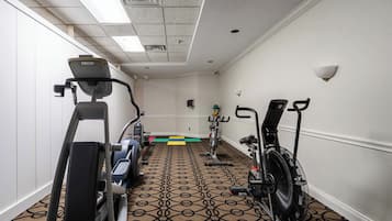 Ein Fitnessraum mit Laufbändern, Ergometer und einem Ventilator.