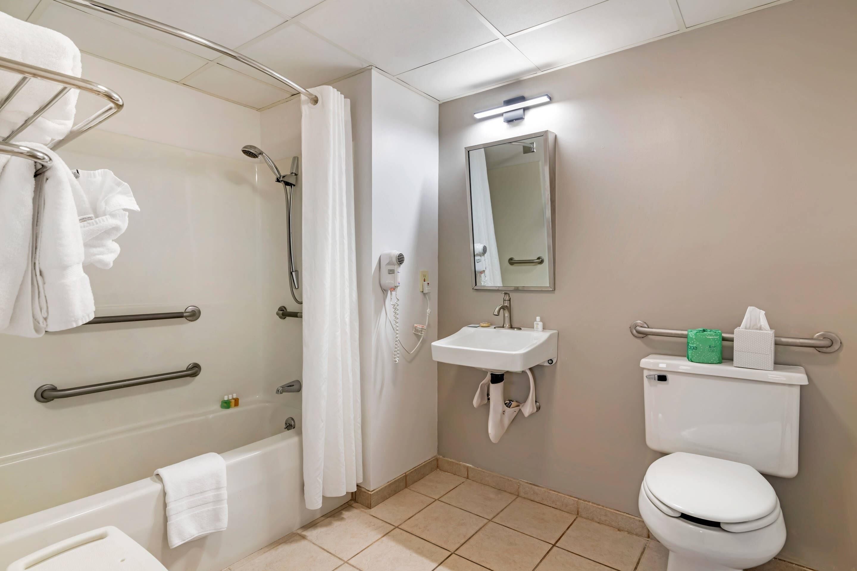A bathroom with a bathtub, shower, toilet, and sink.