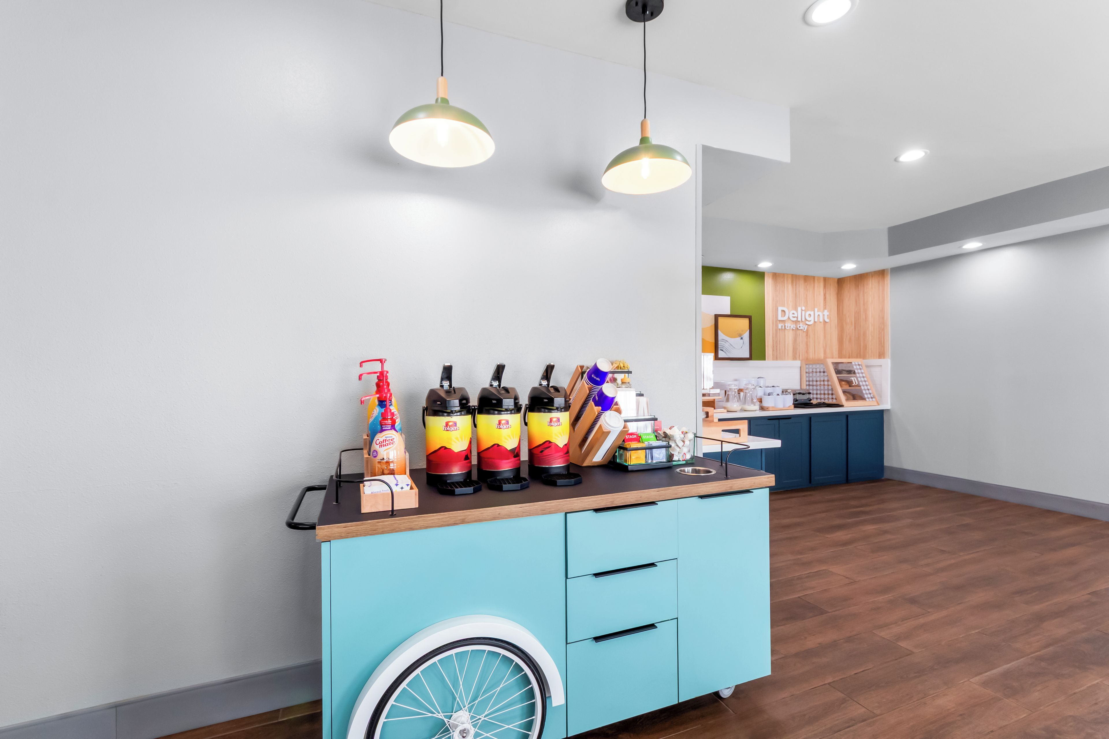 A reception area with a blue counter, a wheelchair-accessible design, and a sign that reads 'Delight in the day.'