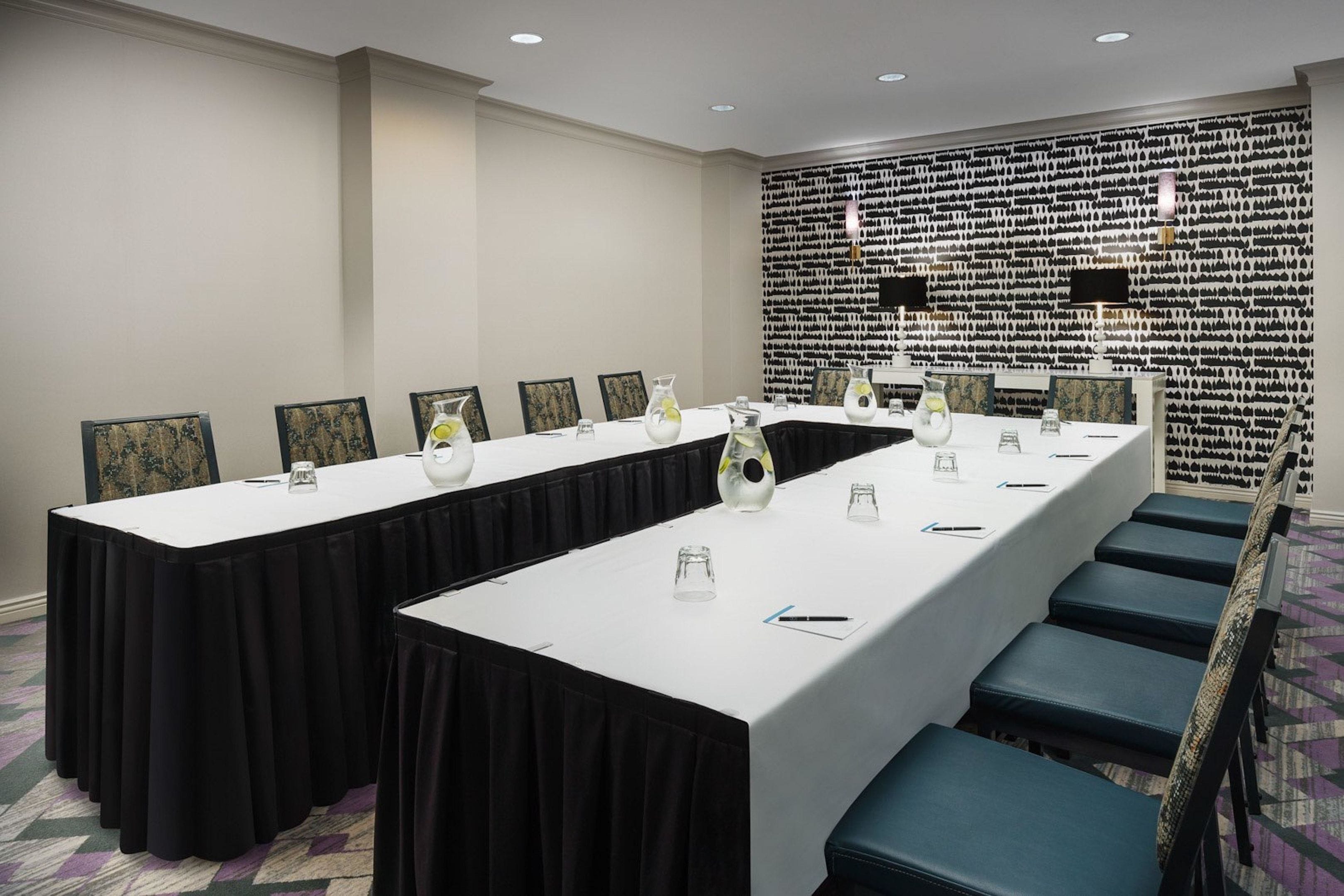 A conference room with a long table, chairs, and a decorative wall.