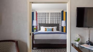 Una habitación de hotel con cama, escritorio, silla y televisión.