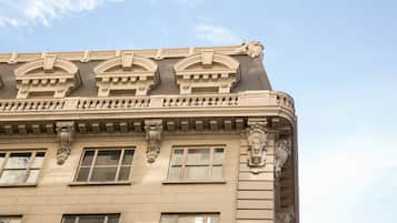 Un bâtiment doté d’éléments architecturaux raffinés, notamment des moulures décoratives et une statue de lion sur le toit.