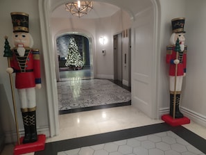 A hallway with a Christmas tree and nutcracker statues.