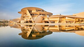 Un edificio de arquitectura moderna con un diseño original y escalonado, reflejado en aguas tranquilas.