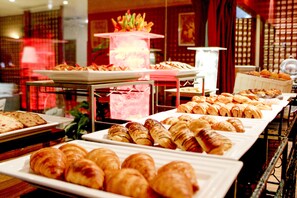 Een buffet met diverse gebakjes en brood.