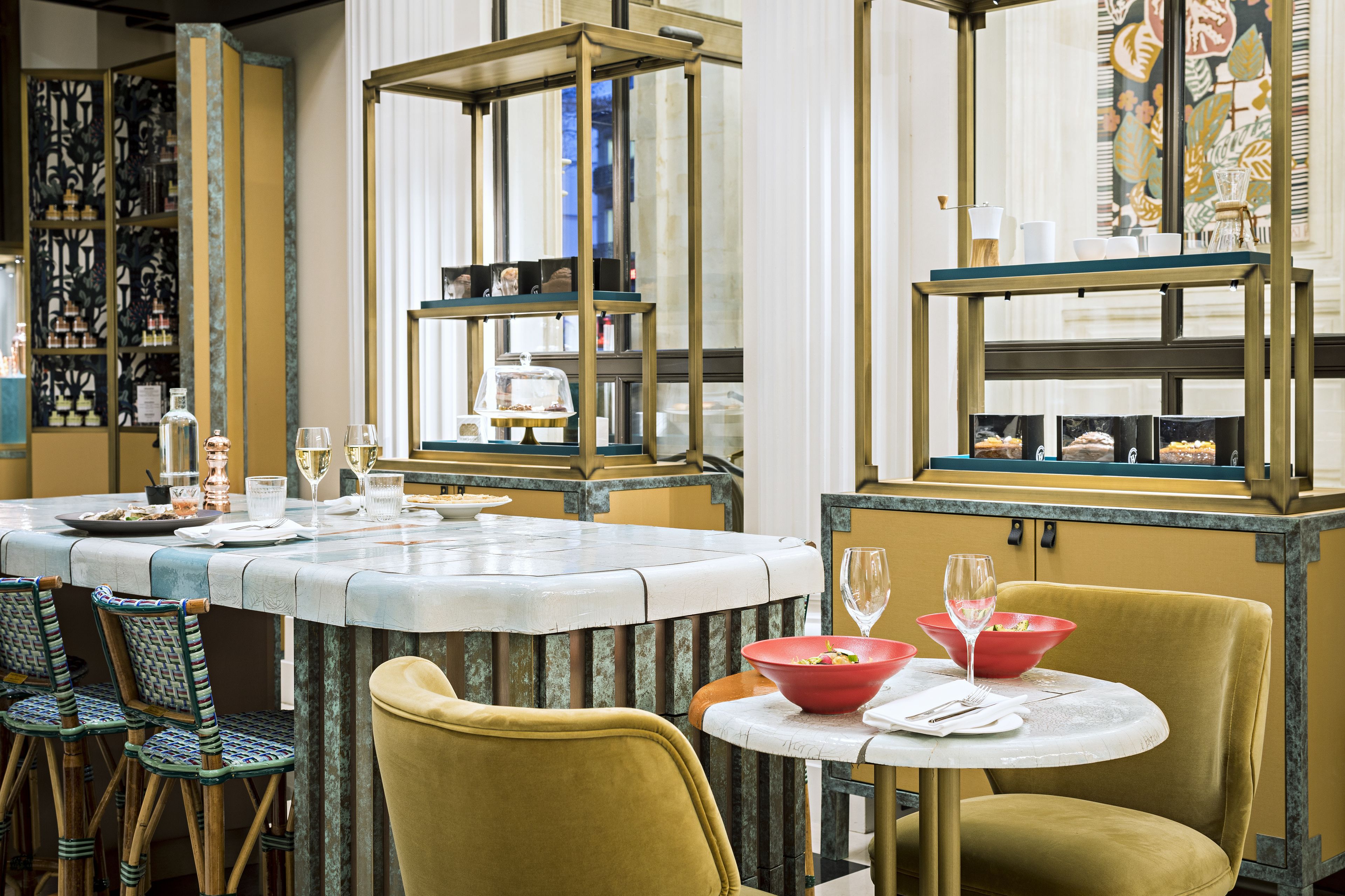 A restaurant with a marble bar, yellow chairs, and a red bowl on a table.