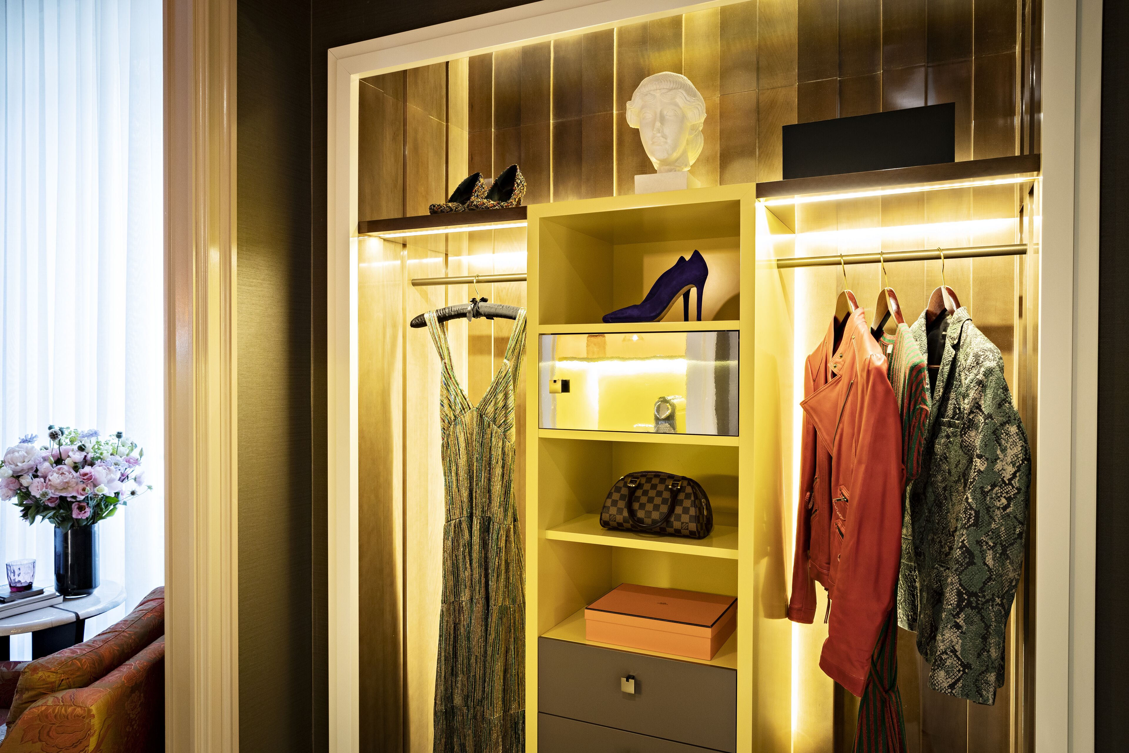 A well-organized closet with shelves, drawers, and hanging space for clothes and shoes.