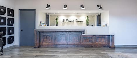 A reception area with a wooden panel counter, a door, and a wall with framed pictures.