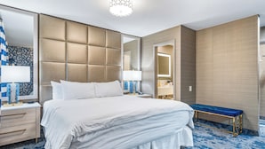 A hotel room with a large bed, a bedside table, a bench, a mirror, and a patterned carpet. - 3 Palms Tucson North Foothills (Tucson)