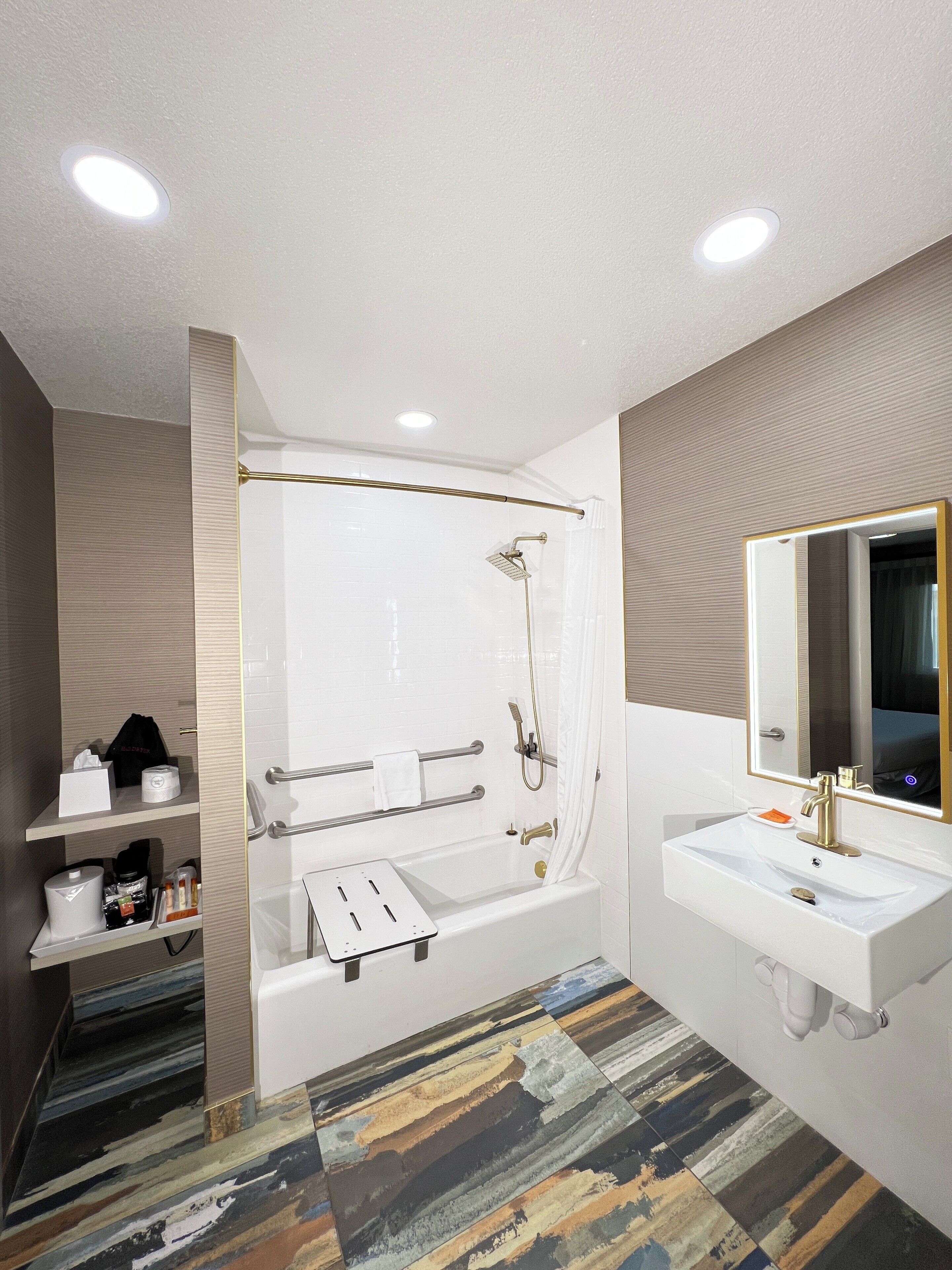 A modern bathroom with a bathtub, a sink, and a mirror.
