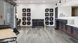 A modern kitchen with a central island, a seating area with a fur throw, and a wall with circular cutouts. - 3 Palms Tucson North Foothills (Tucson)