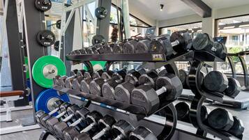 A gym with various weightlifting equipment, including dumbbells and weight plates.