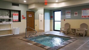 A pool area with a hot tub, chairs, and a towel rack. - Quality Inn & Suites Watertown near Prairie Lakes Ice Arena (Watertown)