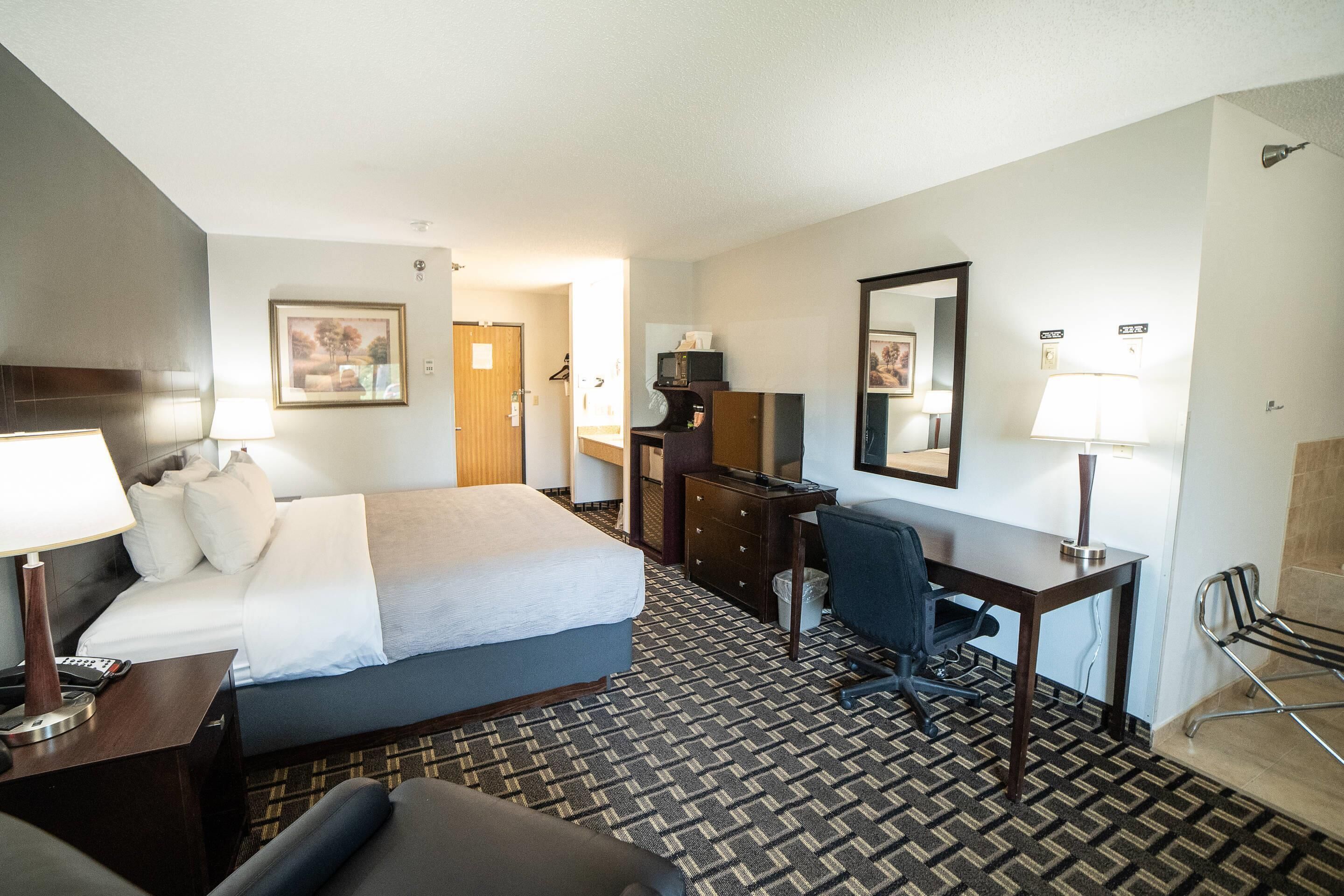 Une chambre d’hôtel équipée d’un lit, d’un bureau, d’une chaise et d’un téléviseur.