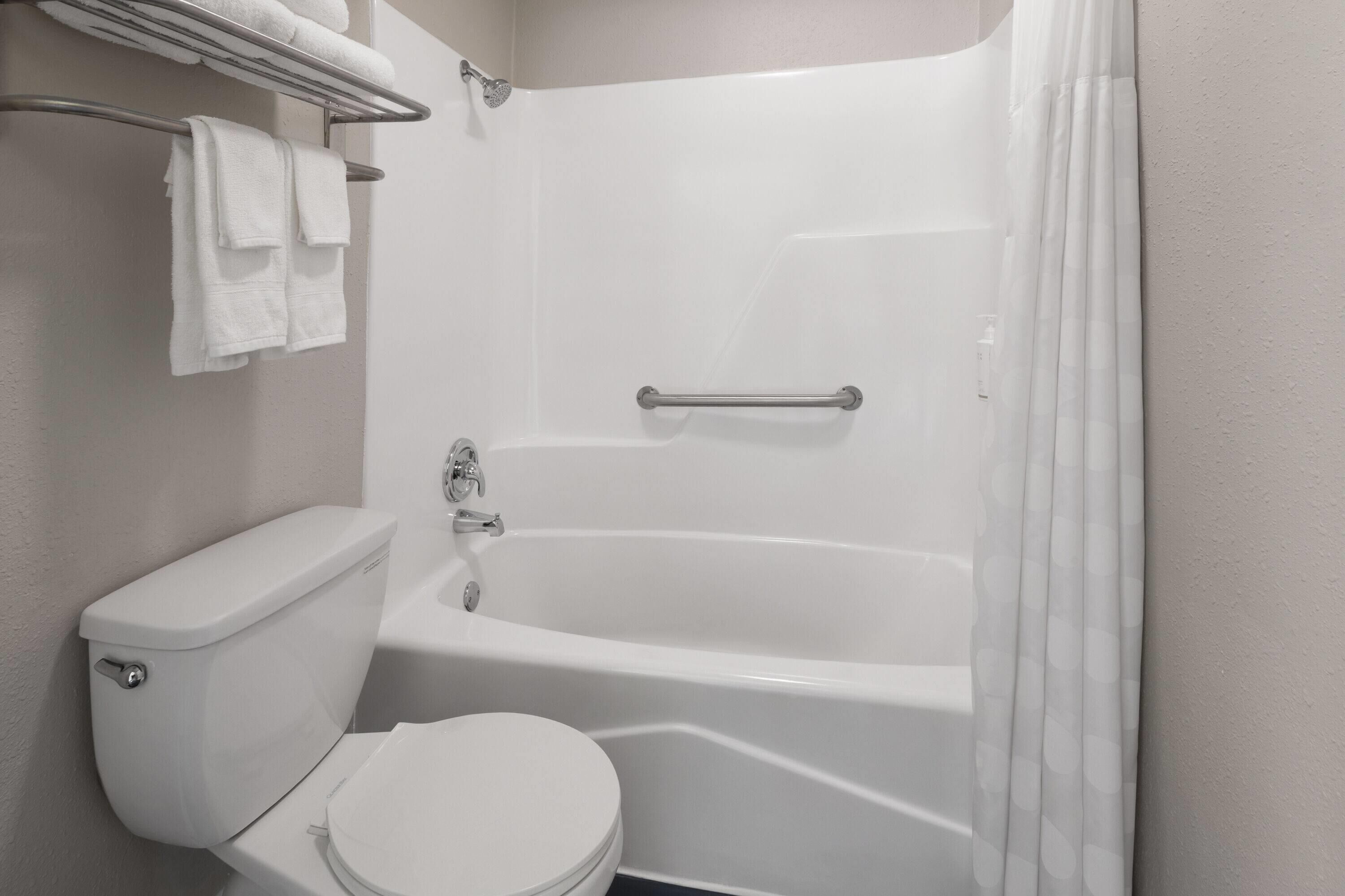 A bathroom with a toilet, bathtub, and shower curtain.