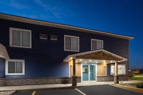 A two-story hotel with a dark blue exterior, a covered entrance, and a visible sign indicating a restaurant.