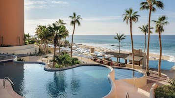 Ein Poolbereich mit Blick auf Strand und Meer.