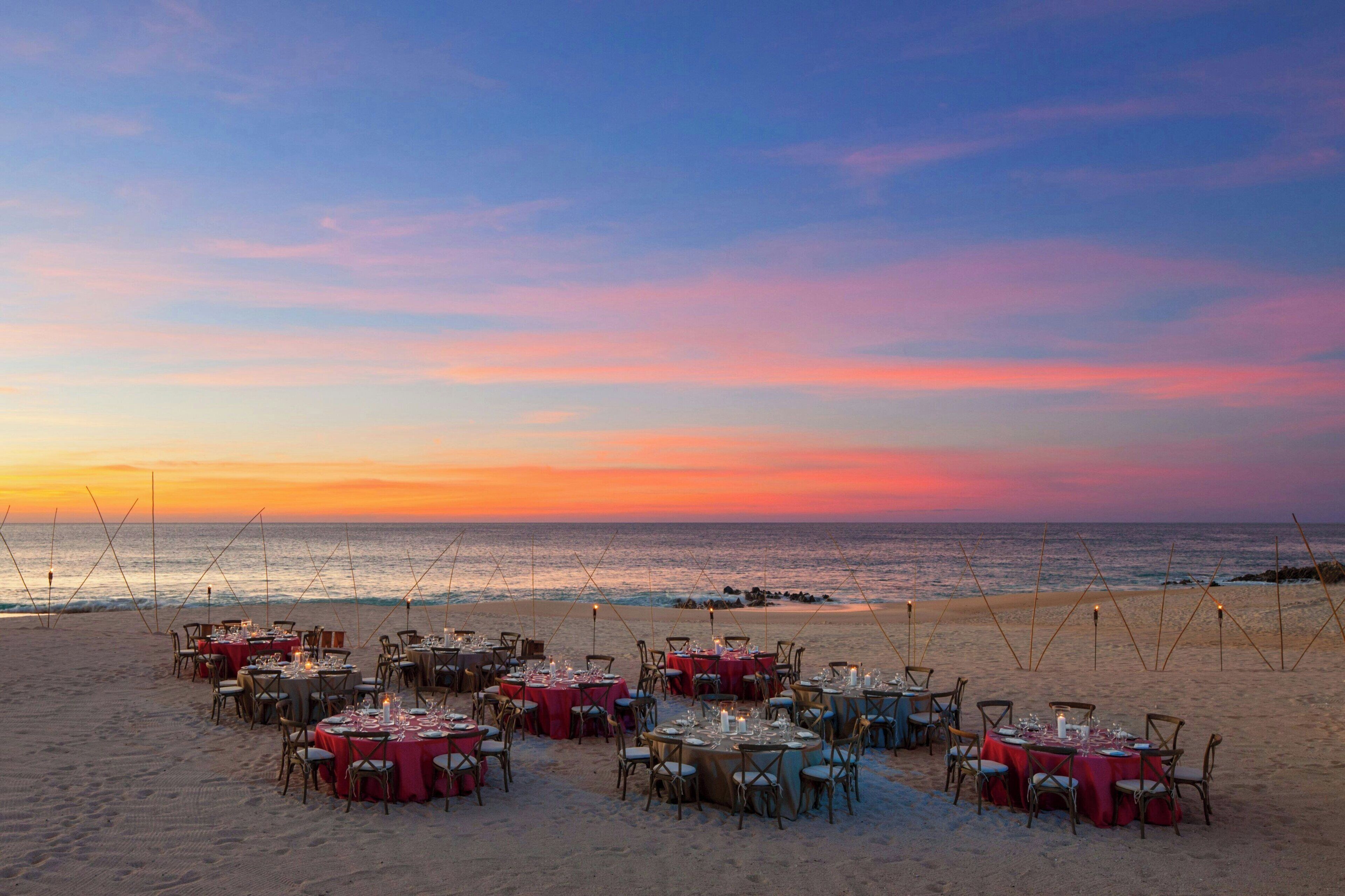 Un espace de restauration aménagé sur la plage, avec des tables disposées pour accueillir les clients, offrant une vue sur l’océan.
