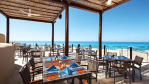 An outdoor dining area with tables and chairs, overlooking the ocean. - The Westin Los Cabos Resort Villas (San José del Cabo)