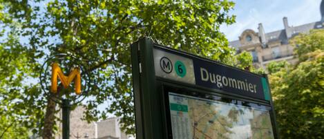 Señal de parada de autobús con 'Dugommier' y un mapa.