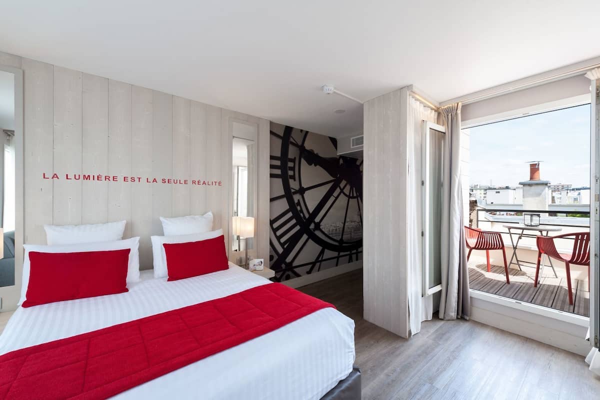 Une chambre d’hôtel avec un lit, une grande fenêtre et une vue sur la ville.