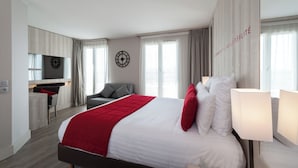 Una habitación de hotel moderna con una cama grande, un escritorio, una silla y un televisor.