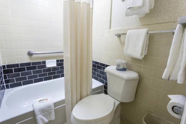 A bathroom with a bathtub, toilet, and a shower curtain.