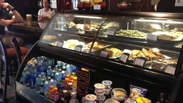 A bakery display case with various baked goods and a selection of beverages.