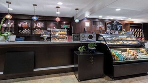 A bakery counter with various baked goods and a coffee machine.