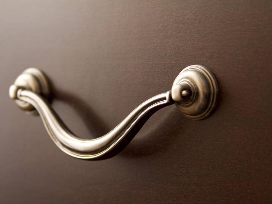 A door handle with a round knob and a curved lever.