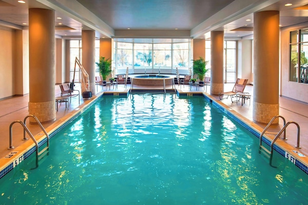 Een binnenzwembad, ligstoelen bij het zwembad