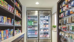 A store with shelves stocked with snacks and beverages, and two refrigerated display cases.