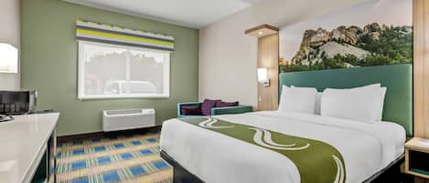 Une chambre d’hôtel équipée d’un lit, d’un bureau, d’une chaise, d’une fenêtre avec stores, d’un climatiseur fixé au mur et d’une fresque murale.