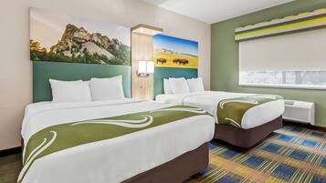 A hotel room with two beds, a large window, and a painting of a mountain and field.