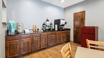 Eine Küche mit Holzausstattung, einer Kaffeemaschine und einem Kühlschrank.