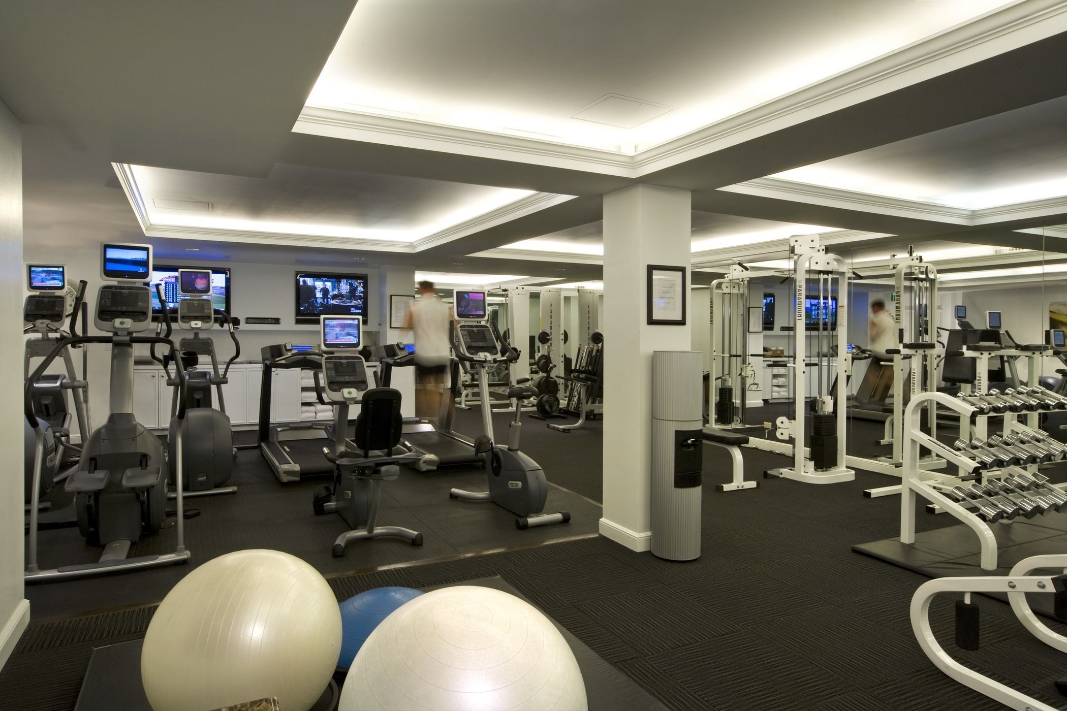 A well-equipped gym with treadmills, elliptical machines, and weightlifting equipment.
