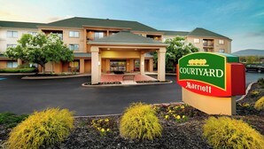 A Courtyard Marriott hotel with a central entrance, landscaped garden, and a parking lot. - Courtyard by Marriott State College (State College)