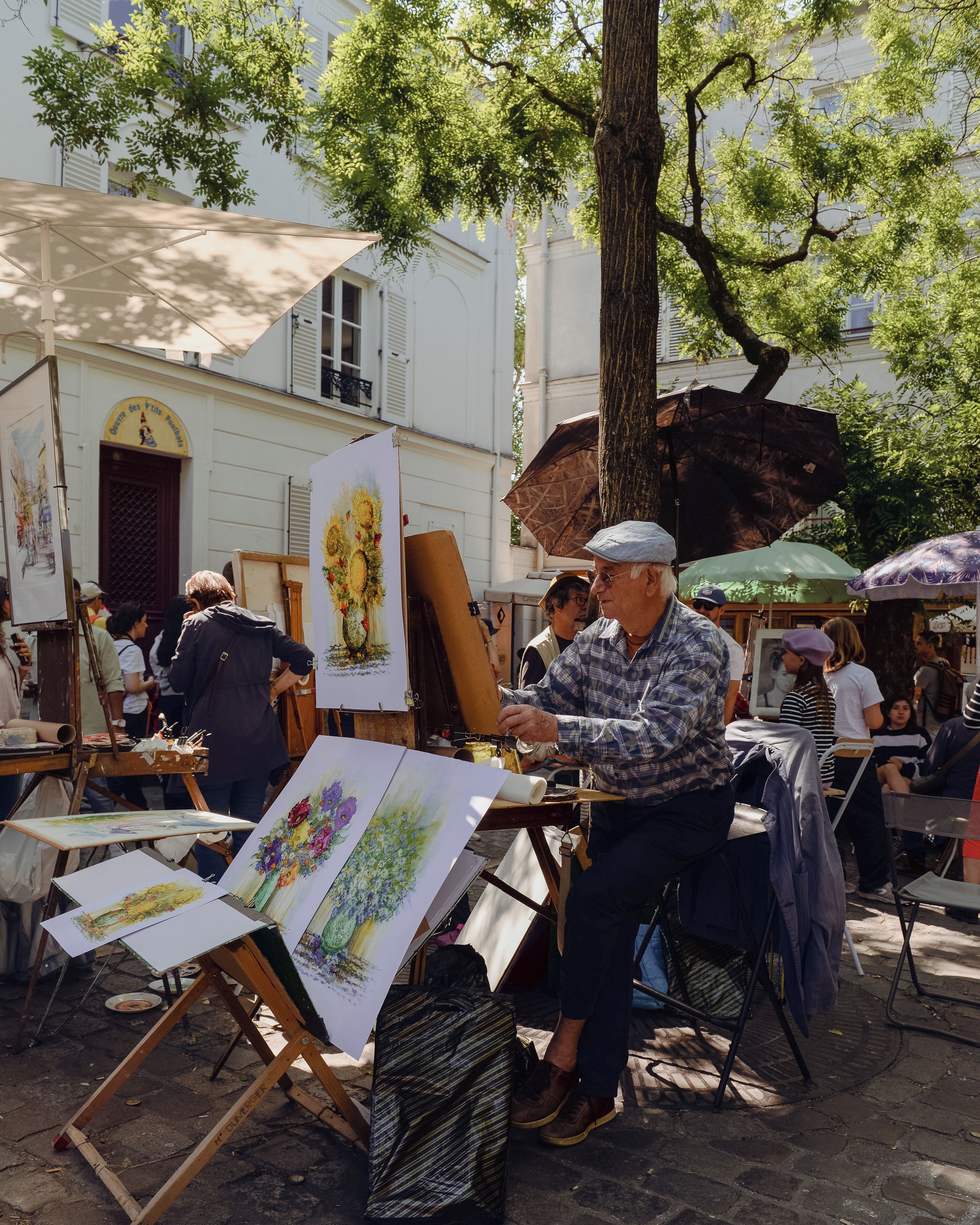 Un marché d’art en plein air avec des chevalets et des tableaux.
