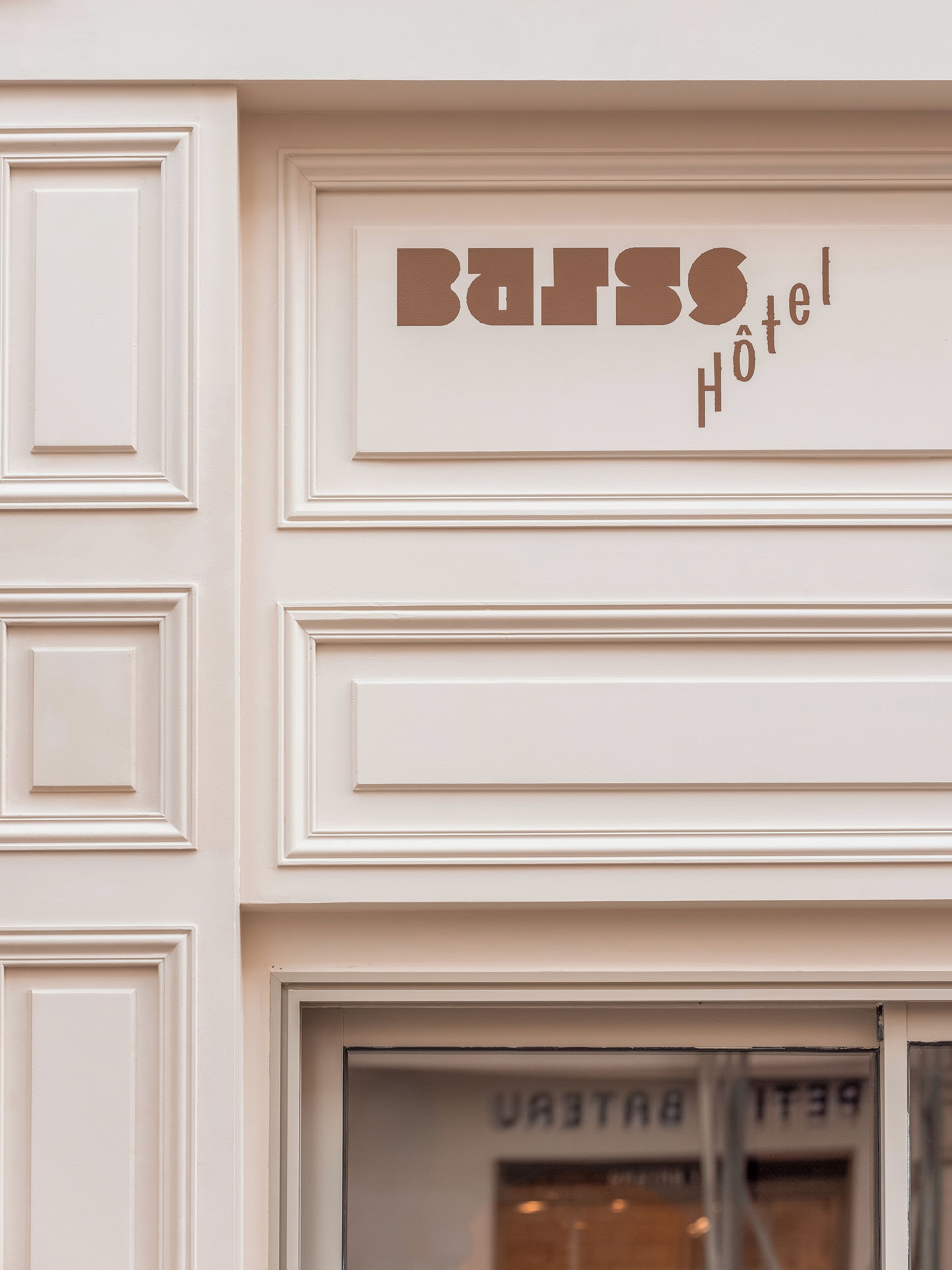A hotel sign with the name "BARSO HOTEL" and a window displaying "BAHRAIN HOTEL".