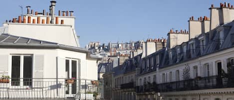 A row of white buildings with balconies and chimneys.