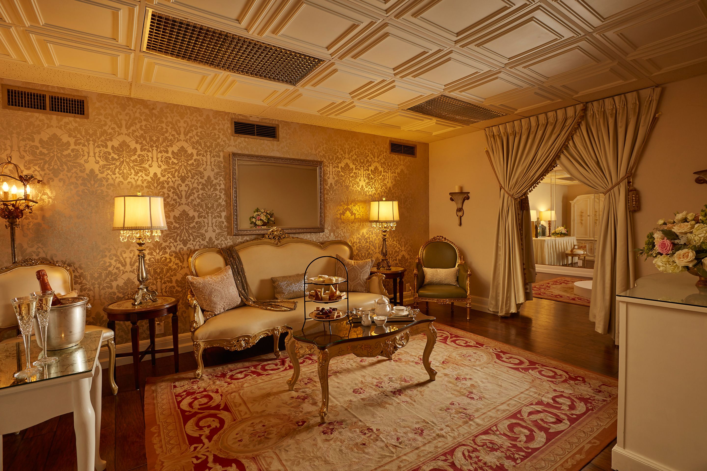 A luxurious room with a sofa, a glass coffee table, and a mirror.