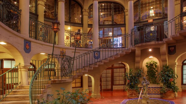 A grand atrium with a central fountain, multiple levels with balconies, and ornate railings. - The Mission Inn Hotel & Spa (Riverside)