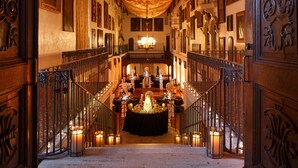 A grand staircase leading to a banquet hall with ornate railings and a chandelier. - The Mission Inn Hotel & Spa (Riverside)