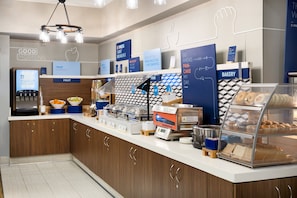 A modern breakfast bar with a digital coffee machine, a fruit display, and a bakery section. - Holiday Inn Express Simi Valley by IHG (Simi Valley)