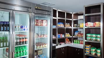 Mostrador refrigerado con diversas bebidas y aperitivos.