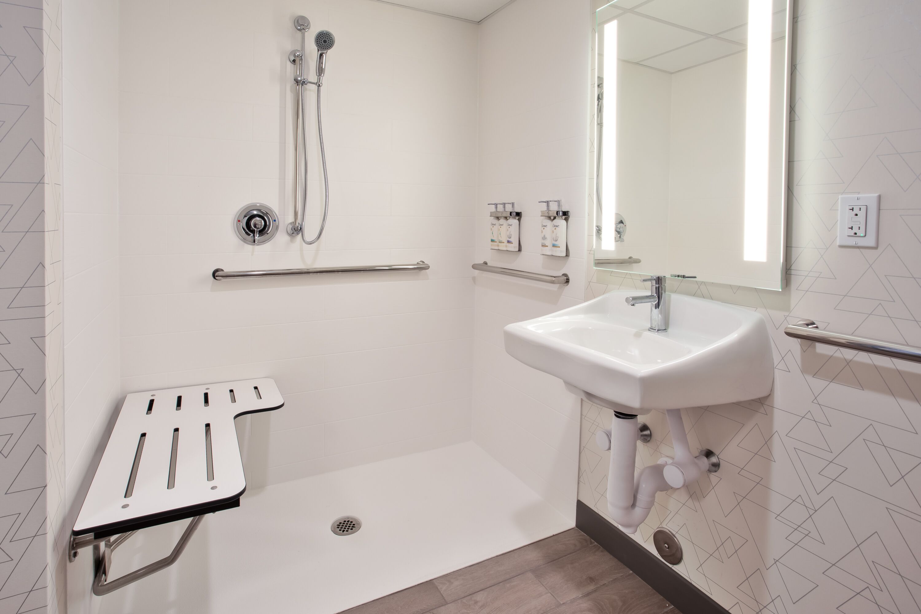A modern bathroom with a shower, a sink, and a grab bar.