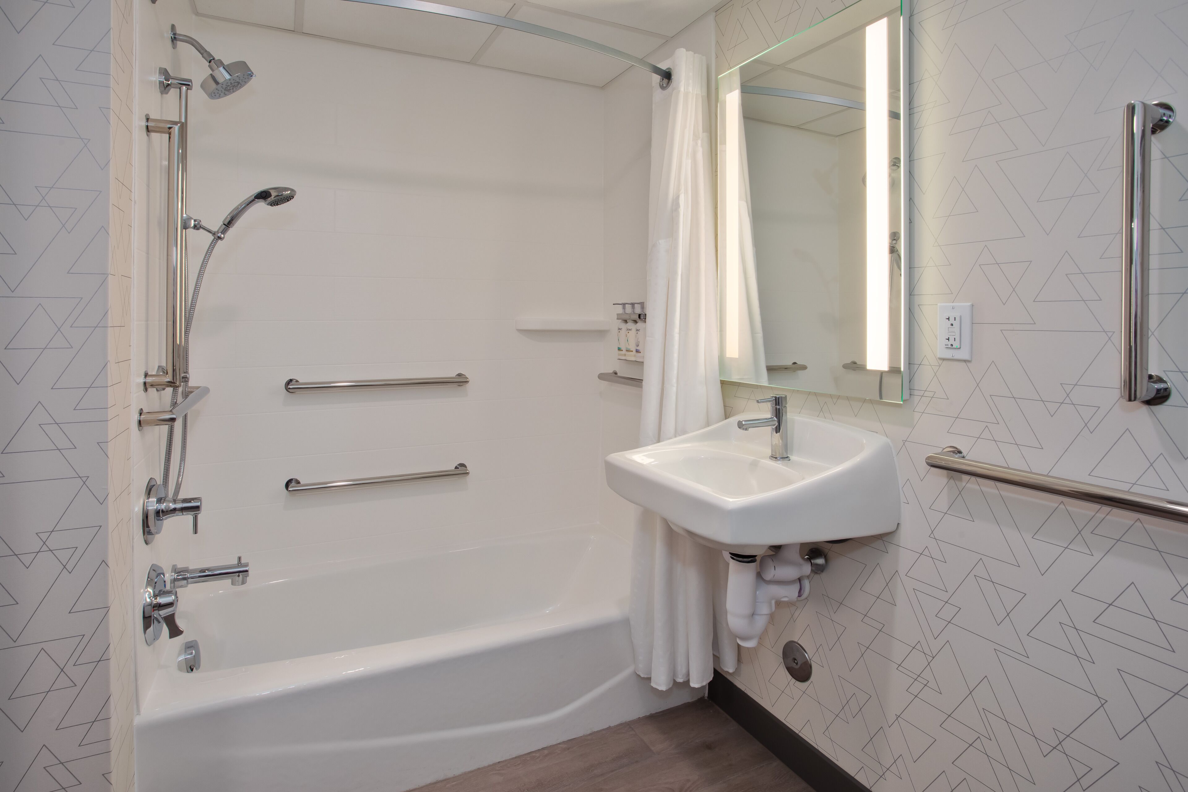 A modern bathroom with a bathtub, shower, and sink.