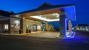 A Holiday Inn Express with a covered outdoor area, a stone facade, and a well-lit entrance. - Holiday Inn Express Kitty Hawk Outer Banks by IHG (Kitty Hawk)