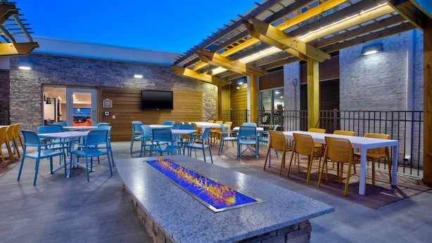 An outdoor patio with seating, a fire feature, and a TV mounted on the wall. - Holiday Inn Express Kitty Hawk Outer Banks by IHG (Kitty Hawk)